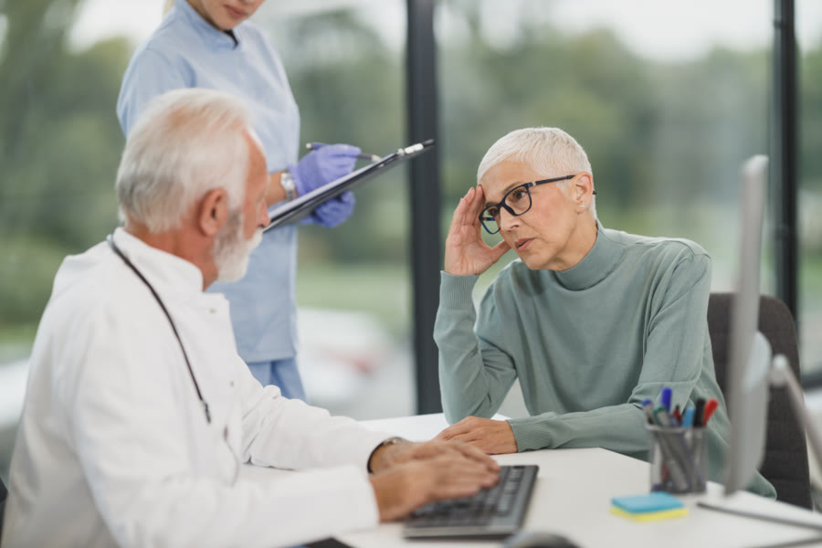Consulta médica: profissional de jaleco atendendo uma paciente