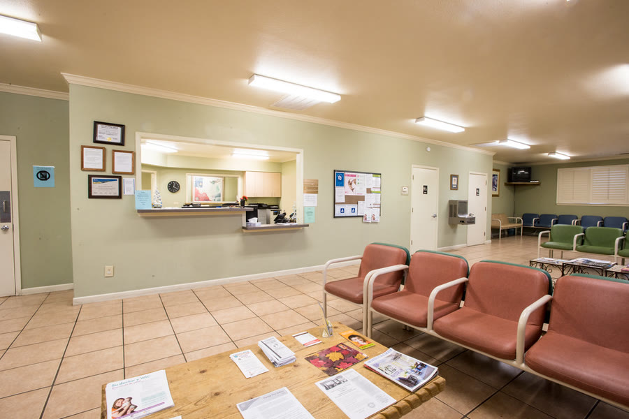 Sala de consultório médico organizada, com maca e escrivaninha