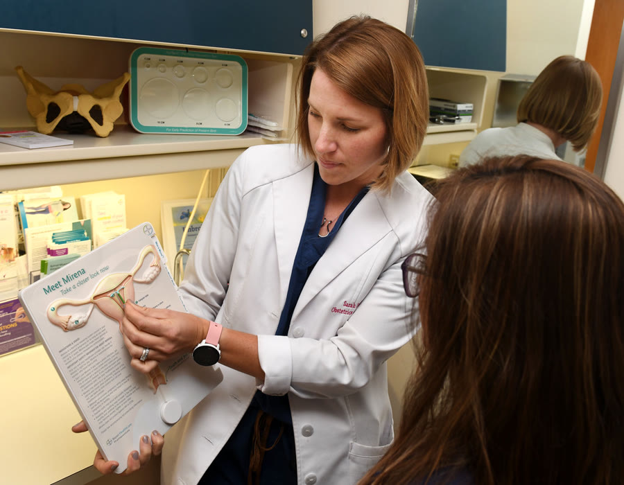 Médica explicando a conduta e anotando orientações